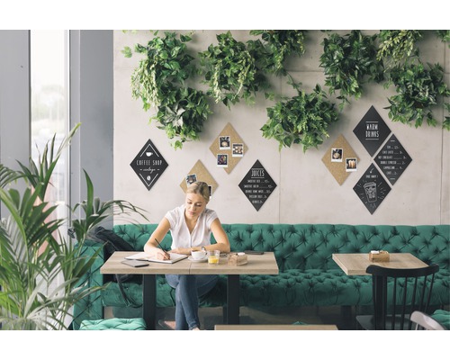 Frau sitzt an einem Tisch in einem Café mit Menütafeln an der Wand.