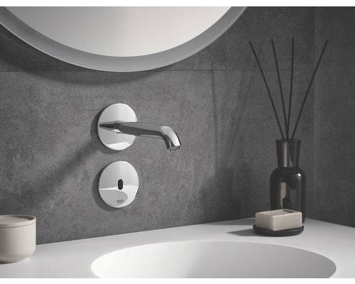 Wandarmatur mit Sensor in einem Badezimmer mit rundem Spiegel