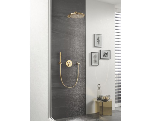 Scène de salle de bains avec système de douche comprenant une douche de tête, une douchette à main et un mitigeur thermostatique