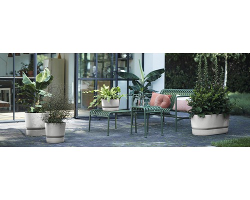 Espace extérieur avec des plantes dans des pots, des sièges et des éléments décoratifs pour une terrasse ou un jardin