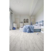 Chambre claire avec lit et plancher en bois