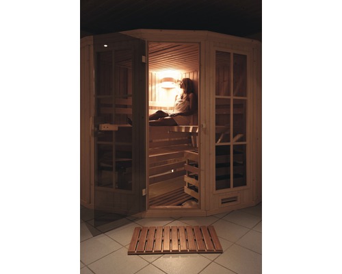 Femme se détend dans un sauna en bois avec façade en verre et plancher en bois