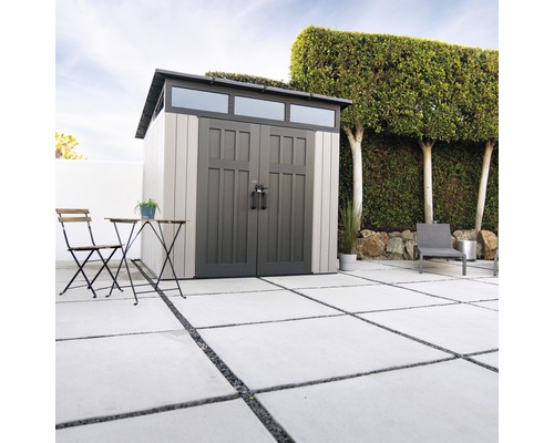 Gartenszene mit Gerätehaus, Gartentisch und Stuhl auf einer Terrasse