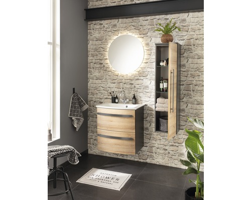 Salle de bain moderne avec meuble-lavabo, miroir éclairé et armoire haute devant un mur en pierre