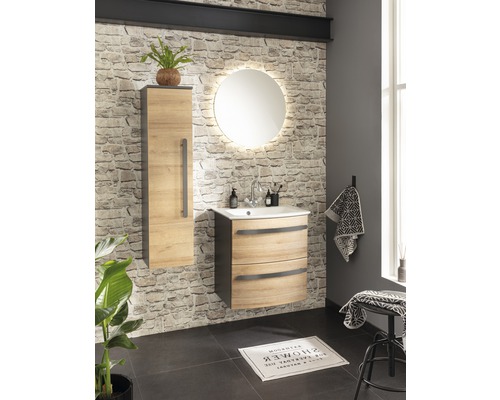 Salle de bains avec meuble-lavabo, armoire de toilette et miroir rond avec éclairage devant un mur en pierre