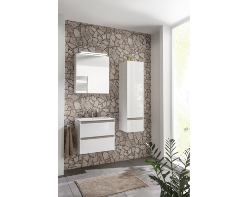 Salle de bain avec meuble sous-lavabo, armoire de toilette et armoire haute devant un mur en pierre