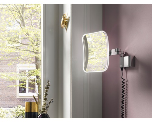 Badezimmer Szene mit beleuchtetem Kosmetikspiegel an einer rosa Wand