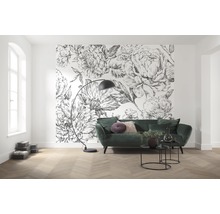 Wohnzimmer mit Blumenmustertapete, grünem Sofa und Stehlampe