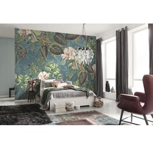 Chambre à coucher avec papier peint floral, lit, tapis et fauteuil