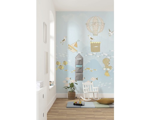 Kinderzimmer mit nautischem Wanddesign, Regal, Schaukelstuhl und Spielmatte