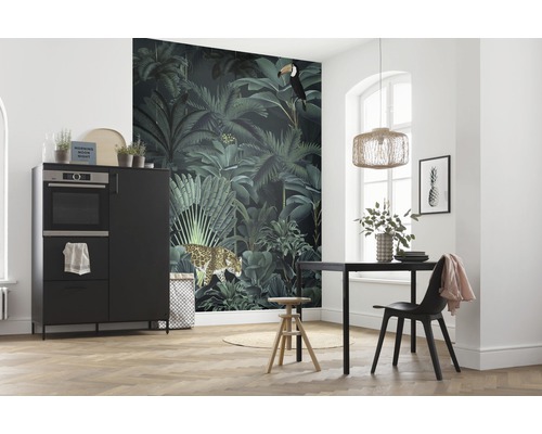 Pièce lumineuse avec papier peint jungle, table à manger, chaise, tabouret et armoire de cuisine