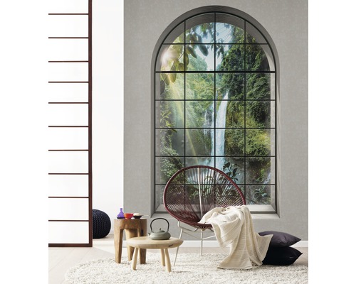 Wohnzimmer mit großem Fenster, Sessel, Tisch und Dekoration