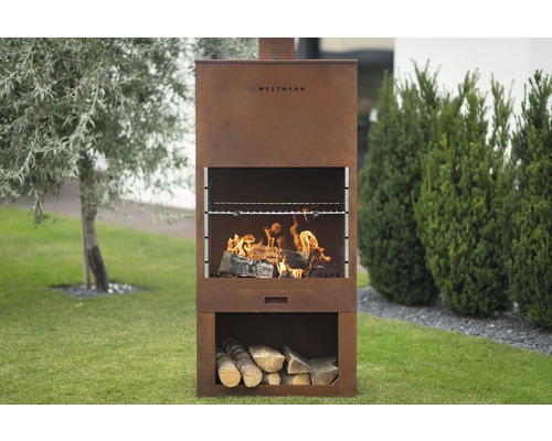 Westmann Grillkamin mit Holzfeuer und Holzscheitlagerung im Garten.