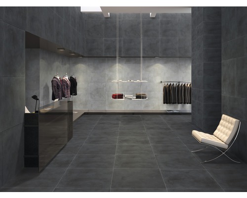 Intérieur avec des carreaux gris sur le sol et les murs dans un magasin de vêtements.