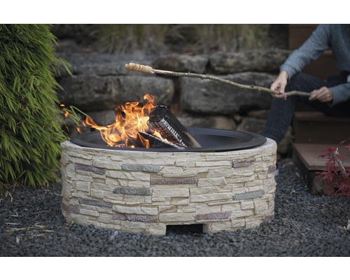 Feuerstelle aus Stein mit Stockbrot über dem Feuer