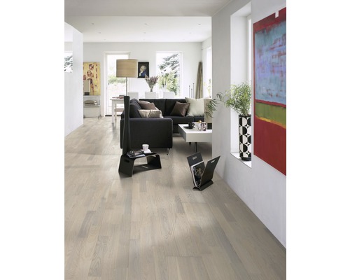 Heller Wohnraum mit Holzboden, Sofa und Kunstwerken