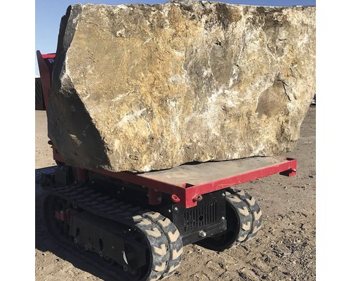 Grosse pierre naturelle sur un transporteur à chenilles