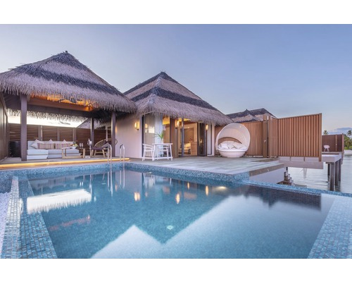 Ansicht eines Bungalows mit Strohdach und Pool