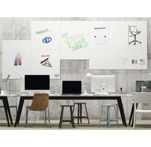 Büro mit Whiteboard-Wand, Tischen, Stühlen und Computern für Brainstorming und Planung