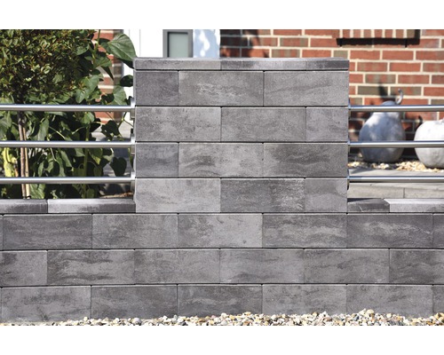 Mauer aus grauen Betonsteinen mit Metallelementen