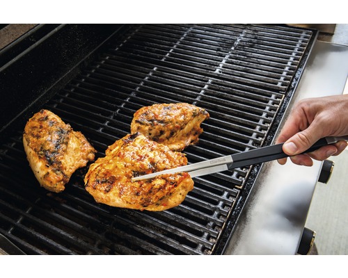 Poulet grillé sur un barbecue avec une pince à grill