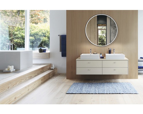 Salle de bains avec meuble double vasque, miroir avec éclairage et baignoire sur un niveau surélevé