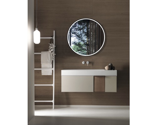 Modernes Badezimmer mit Waschtisch, rundem Spiegel, Handtuchleiter und Holzwandverkleidung.