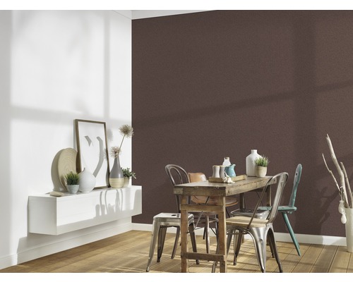 Esszimmer mit brauner Wandtapete, Holztisch und Stühlen.