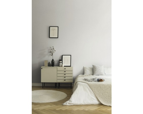 Schlafzimmer mit Kommode, Bett und rundem Teppich