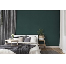 Chambre avec lit, table d''appoint et mur vert