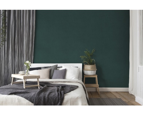 Chambre avec lit, table d''appoint et mur vert