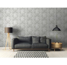 Wohnzimmer mit gemusterter Tapete, Sofa, Stehlampe und Beistelltisch