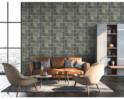Wohnzimmer mit braunem Ledersofa, Sesseln und Wandtapete mit Blättermuster