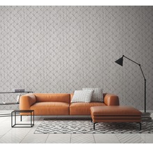 Salon avec canapé orange, tapis géométrique et lampadaire devant un mur à motifs
