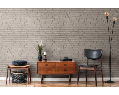 Dekorative Wand mit Mauerwerkstapete, Holzkommode und Lampe