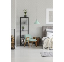Schlafzimmer mit Bett, Sessel, Regal und Pendelleuchte