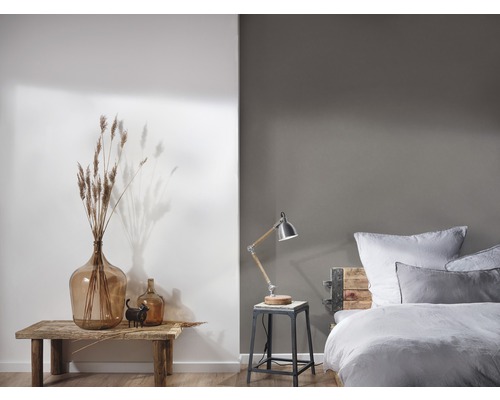 Schlafzimmer mit Bett, Nachttischlampe und Dekoration auf einem Holztisch