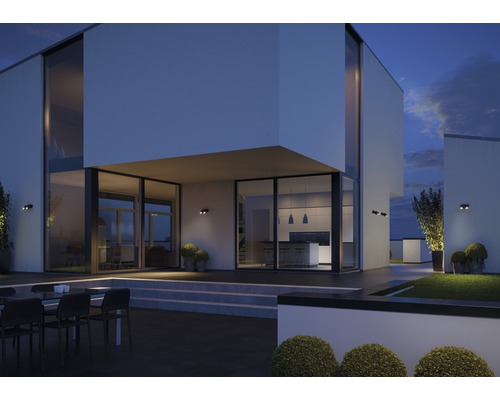 Moderne Hausfassade mit Aussenbeleuchtung und Gartenbereich bei Dämmerung