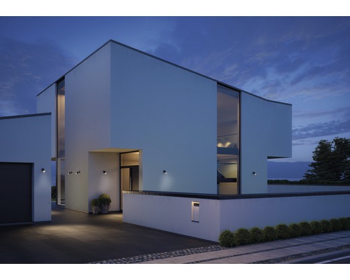 Modernes Haus mit Aussenbeleuchtung und grossen Fensterfronten bei Dämmerung