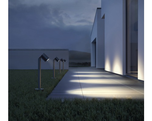 Rangée de luminaires de jardin le long d''un chemin devant une maison moderne