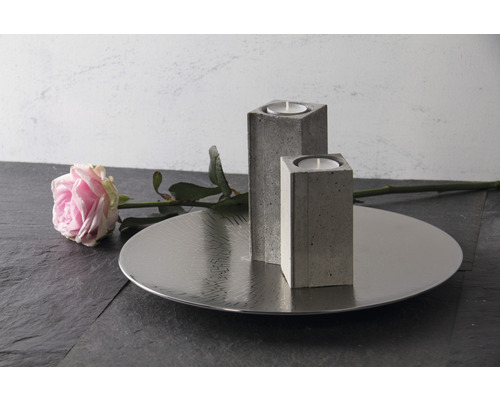 Dekoration mit zwei Kerzenhaltern aus Beton, einem silberfarbenen Tablett und einer Rose