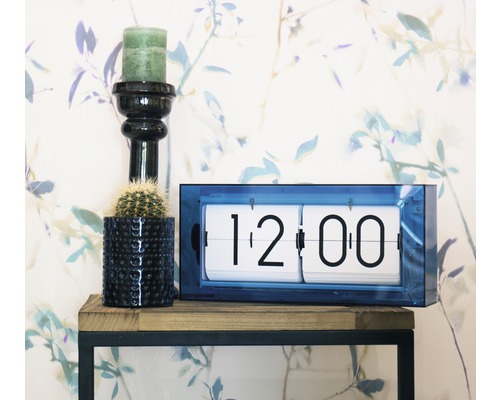 Dekorative Szene mit Klappzahlenuhr, Kerze und Kaktus auf einem Regal