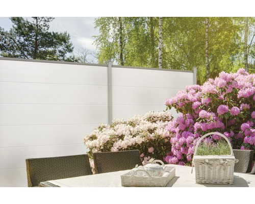 Scène de jardin avec clôture d''intimité, table et fleurs