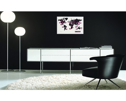 Interieur mit zwei Stehlampen, einem Sideboard, einem Sessel und einer Weltkarte an der Wand.