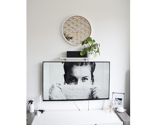 Wohnzimmer mit geometrischer Wanduhr und Fernseher