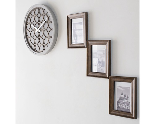 Horloge murale et trois cadres photo sur le mur