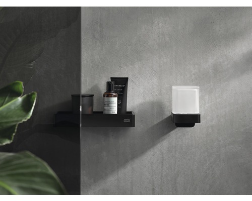 Schwarzes Badezimmerregal und Seifenspender an einer Wand montiert