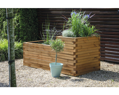 Jardinière décorative en bois avec des plantes dans le jardin.