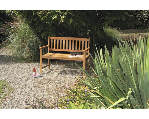 Banc de jardin en bois dans un jardin avec de la végétation