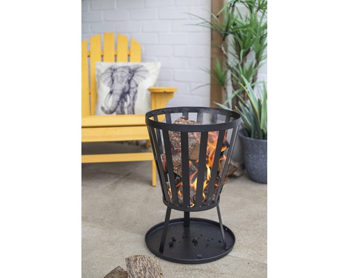 Brasero avec bûches de bois sur une terrasse avec mobilier de jardin